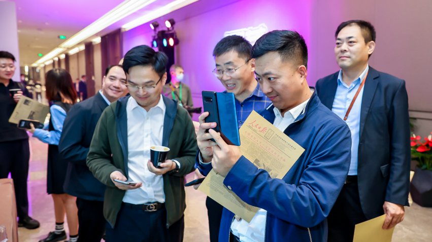 人民網(wǎng)研發(fā)推出的《人民日?qǐng)?bào)》生日?qǐng)?bào)吸引嘉賓體驗(yàn)。主辦方供圖